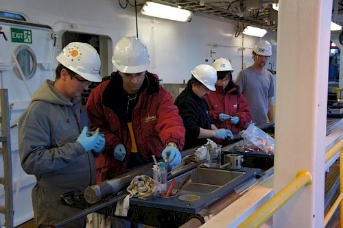 I ricercatori dell'Agenzia giapponese per le scienze e le tecnologie marine e terrestri mentre studiano i campioni di materiale. Credits: IODP JRSO/ Nature Communications